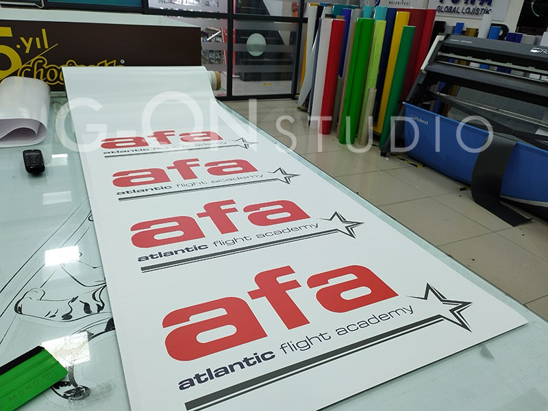 AFA Atlantic Flight Academy logolu mıknatıs etiketler baskı çıktısı olarak masada